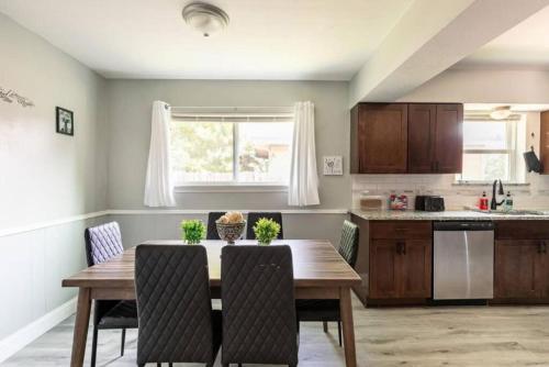 a kitchen with a wooden table and chairs in a kitchen at 4 Bed 3 Bath House, Spacious, Smart TVs in all rooms, Whole house to yourself in Garland