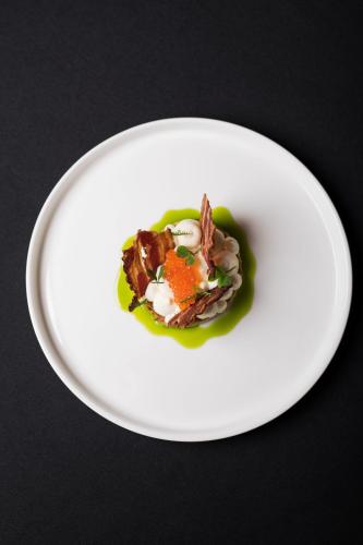 a white plate with a dish of food on a table at HOT_elarnia Hotel & Spa in Puszczykowo