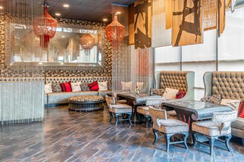 a lobby with tables and chairs and a couch at Hotel Huntington Beach in Huntington Beach