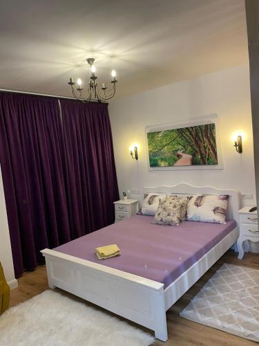 a bedroom with a large bed with purple sheets at Apartament Gabriela 39 in Baia Mare