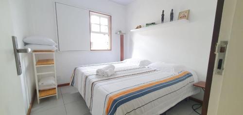 a white room with a bed and a window at Lurgar Apart in Ouro Preto