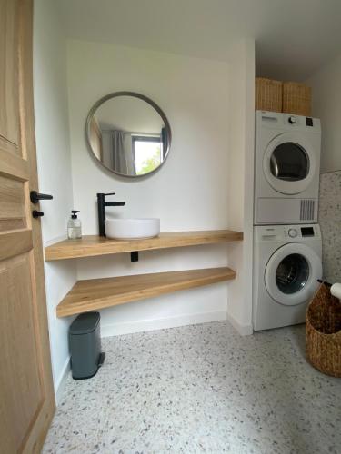 ein Badezimmer mit einem Waschbecken und einer Waschmaschine in der Unterkunft Magnifique villa avec piscine, à 5 min des plages in Landunvez