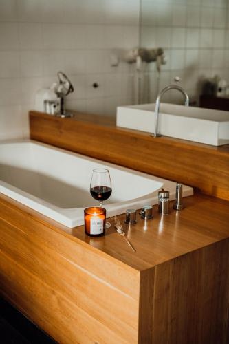 a glass of wine sitting on a counter next to a bath tub at HOT_elarnia Hotel & Spa in Puszczykowo