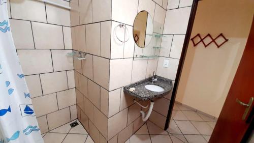 a small bathroom with a sink and a mirror at Pousada Anauê - Conde in Jacumã