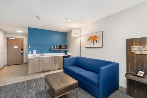 a living room with a blue couch and a kitchen at Holiday Inn Express Peru-Lasalle Area, an IHG Hotel in Peru