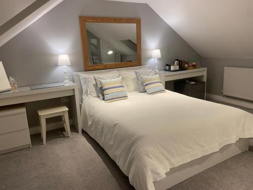 Rosenn Teyr في سانت أغنس: غرفة نوم مع سرير أبيض كبير مع مرآة