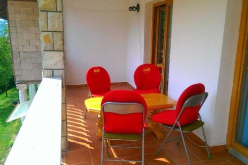 une salle à manger avec des chaises rouges et une table jaune dans l'établissement Vila Afan Ušivak, à Sarajevo