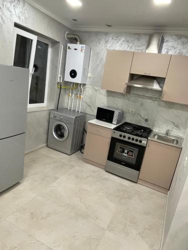 una cocina con estufa y lavadora en Albus house, en Gyumri