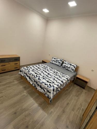 1 dormitorio con 1 cama y suelo de madera en Albus house, en Gyumri