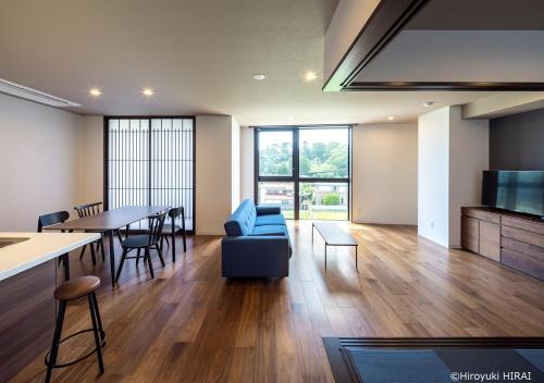 un soggiorno con divano blu e tavolo di THE VIEW Odawara shiro-no mieru hotel - Vacation STAY 66090v a Odawara