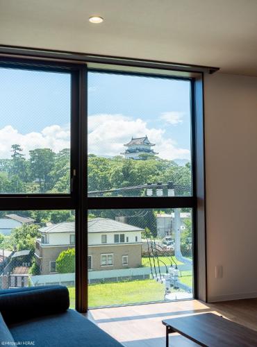 een kamer met een groot raam met uitzicht op een gebouw bij THE VIEW Odawara shiro-no mieru hotel - Vacation STAY 66090v in Odawara