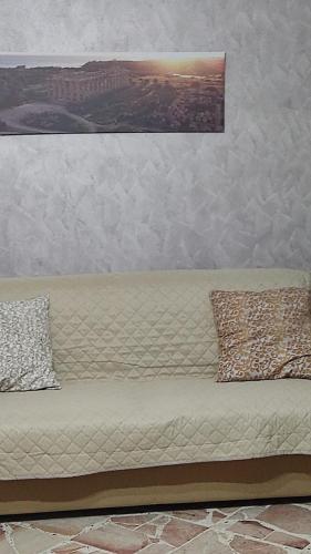 a couch with two pillows on it in a room at La Dolce Oasi in Triscina