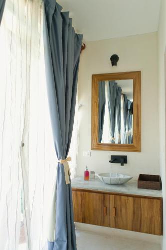 a bathroom with a sink and a mirror and a curtain at Saak Luúm Ruta Puuc in Sacalum
