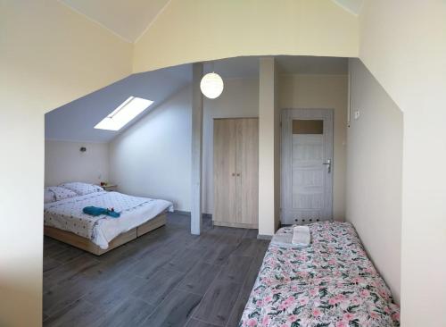 um quarto no sótão com uma cama e uma janela em Lawendowy Dworek em Bałtów