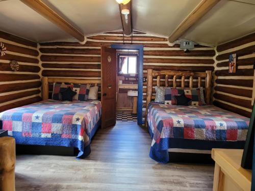 2 camas en una habitación con paredes de madera en Chinook Cabins & RV Park, en South Fork