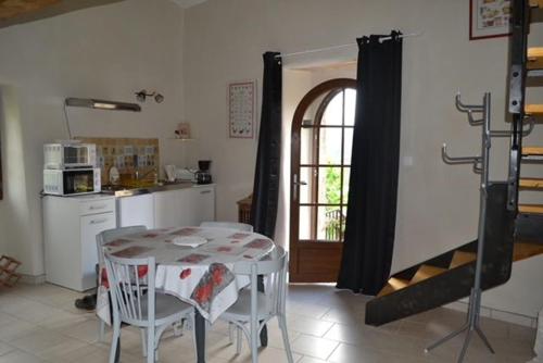 a kitchen with a table and chairs and a kitchen with a window at Gite rural au calme en Cévennes Gardoises in Saint-Jean-du-Gard