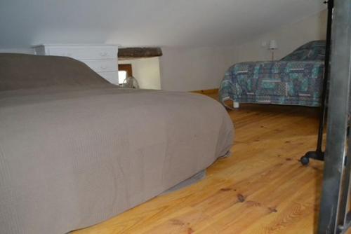 une chambre avec un lit et un parquet dans l'établissement Gite rural au calme en Cévennes Gardoises, à Saint-Jean-du-Gard