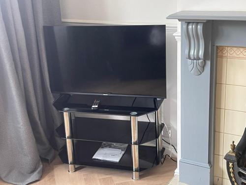 a flat screen tv on a stand in a living room at Lovely, recently refurbished four bedroom house.. in Hither Green
