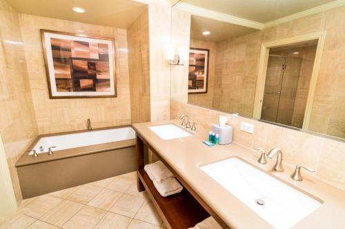 Holiday Inn Express & Suites Las Vegas SW Springvalley, an IHG Hotel في لاس فيغاس: حمام مع مغسلتين وحوض استحمام ومرآة
