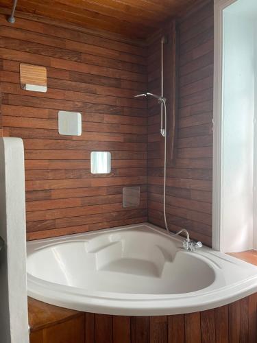 a bath tub in a bathroom with wooden walls at Yvana in Concarneau