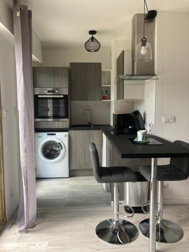 a kitchen with a table and a washer and dryer at Les Mélèzes 1 Studio in Barcelonnette