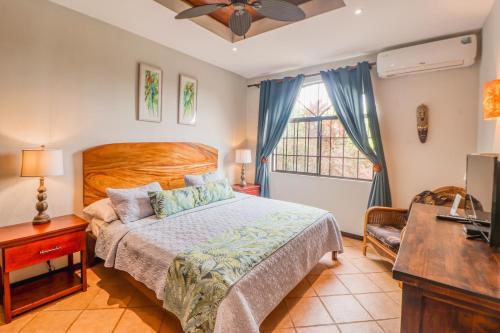 a bedroom with a bed and a desk and a television at Casa Mimosa in Playa Flamingo