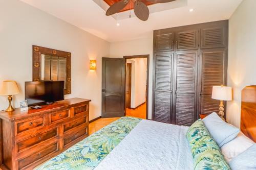 a bedroom with a bed and a flat screen tv at Casa Mimosa in Playa Flamingo