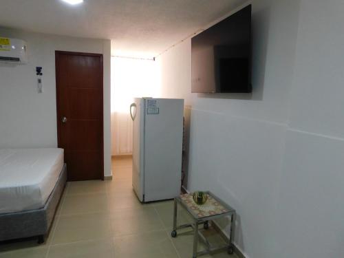 a small room with a refrigerator and a table in it at El Velero Apartamentos By DANP in Santa Marta