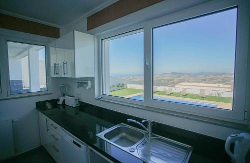 a kitchen with a sink and two windows at Villa Tanger in Tangier