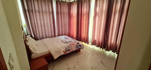a small bedroom with a bed and a window at Penthouse au coeur de Yaoundé Quartier Bastos in Yaoundé
