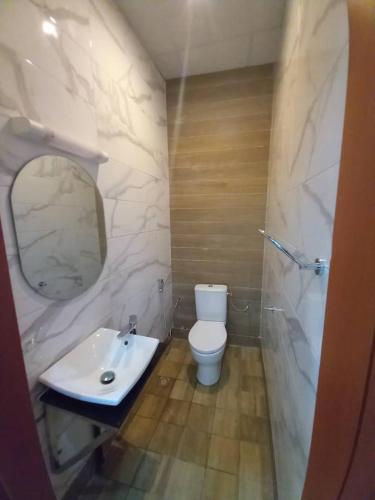 a bathroom with a white toilet and a sink at Penthouse au coeur de Yaoundé Quartier Bastos in Yaoundé