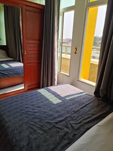 a bedroom with a bed next to a window at Penthouse au coeur de Yaoundé Quartier Bastos in Yaoundé