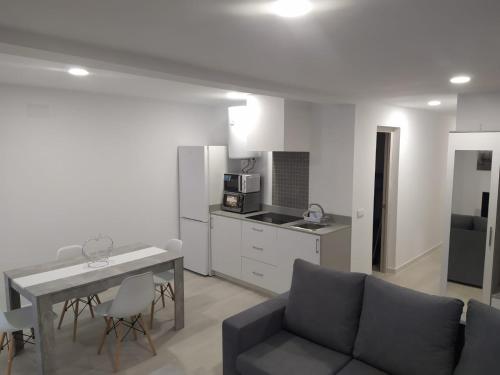 ein Wohnzimmer mit einem Sofa und einem Tisch sowie eine Küche in der Unterkunft Villa Romadian in Chiclana de la Frontera