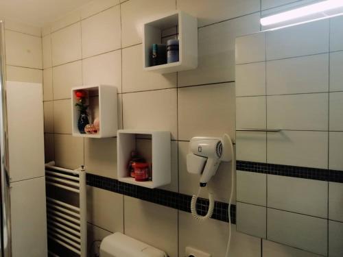 a bathroom with a phone on a tiled wall at APARTMAN D&D*** in Varaždin