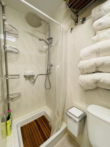 a bathroom with a shower with a toilet and towels at FLAT Surrounded by Nature WIFI & Pool & beach Nearby in Son Parc