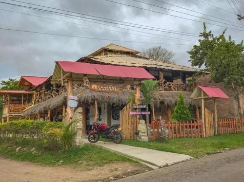 a house with a motorcycle parked in front of it at Cabañas Guacari San Agustín huila in San Agustín