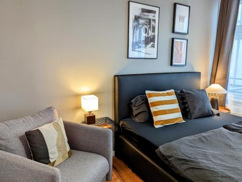 a bedroom with a bed and a couch and a chair at Leipzig Residenz City-Center Apartments in Leipzig