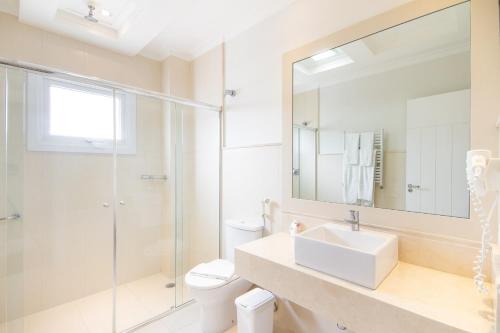 a bathroom with a toilet and a sink and a shower at Pousada Italia Eleganza in Campos do Jordão