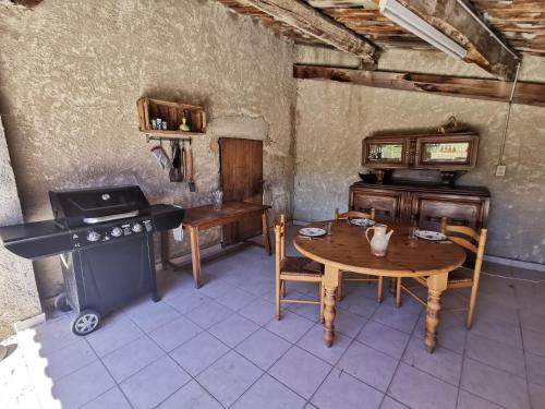 Cette chambre comprend une table et une cuisinière. dans l'établissement La suite du beffroi, à Malaucène