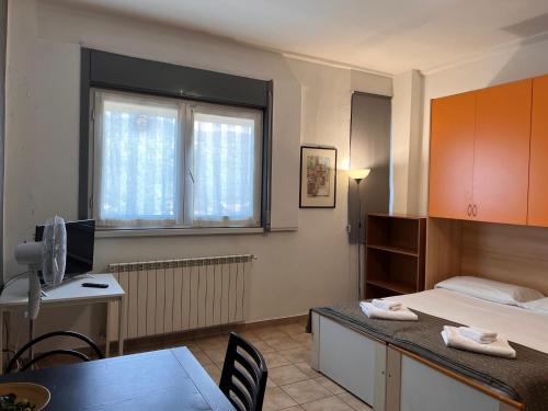Zimmer mit einem Schreibtisch, einem Bett und einem Fenster in der Unterkunft Appartamenti La Chiocciola Como - Lipomo in Como