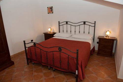 a bedroom with a bed with a red blanket and two night stands at Casa Vacanze - B&B Il Tempone in Prignano Cilento