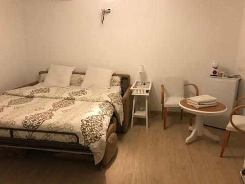 une chambre avec un lit, une table et des chaises dans l'établissement Chambre cosy 25m2, à Collobrières