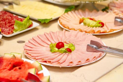 a table topped with plates of food with fruit on them at Pousada Italia Eleganza in Campos do Jordão