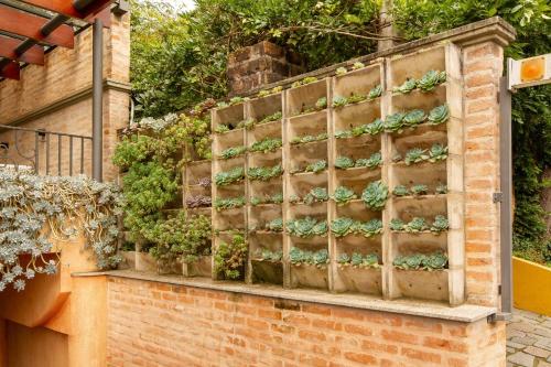 a brick wall with potted plants on it at Pousada Italia Eleganza in Campos do Jordão