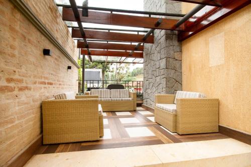 a room with chairs and a brick wall at Pousada Italia Eleganza in Campos do Jordão