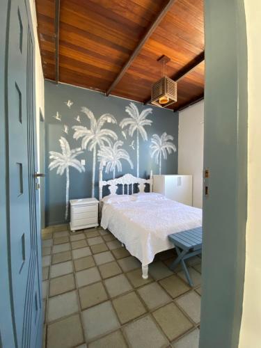 Schlafzimmer mit einem Bett und Palmen an der Wand in der Unterkunft Exclusiva Casa na Melhor Praia de Aracaju in Aracaju