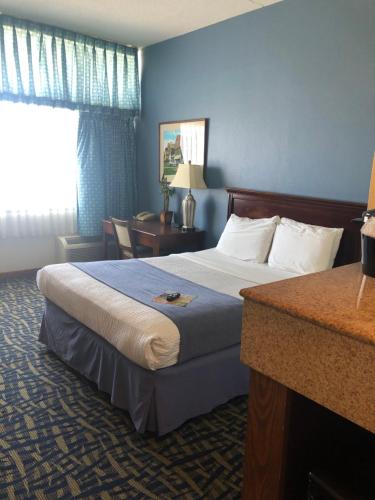 a hotel room with a bed and a desk at Capes Hotel in Virginia Beach