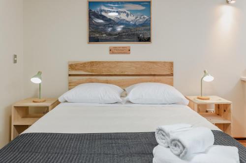 a bedroom with a bed with two white pillows at Cerros Apart Hotel in Coihaique