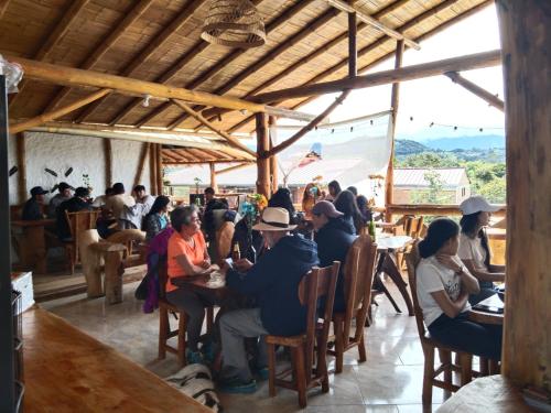 a group of people sitting at tables in a restaurant at Cabañas Guacari San Agustín huila in San Agustín