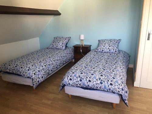 2 letti in una camera con pareti blu di gite des 3 pleureuses a Saint-Riquier